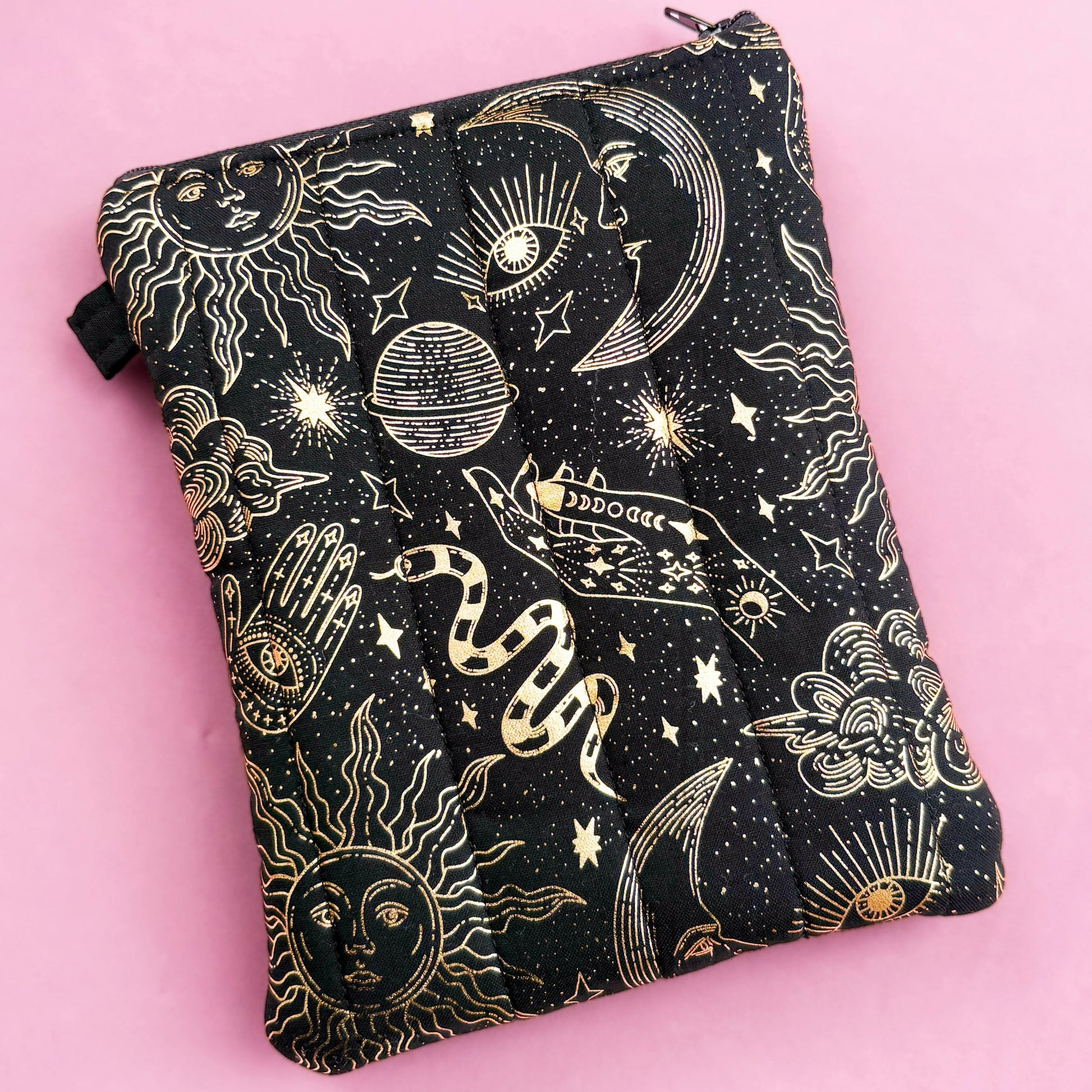 A black and gold pouch with a starry night sky design, featuring various celestial objects such as stars, planets, and a crescent moon.