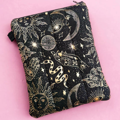 A black and gold pouch with a starry night sky design, featuring various celestial objects such as stars, planets, and a crescent moon.