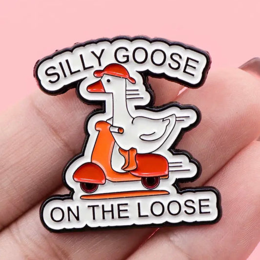 Pin with a goose on a scooter and text 'Silly Goose on the Loose' held in hand against pink background